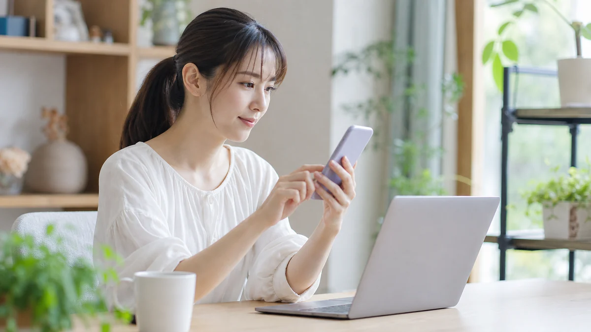アンケート依頼メールの受信設定をスマートフォンで確認する女性