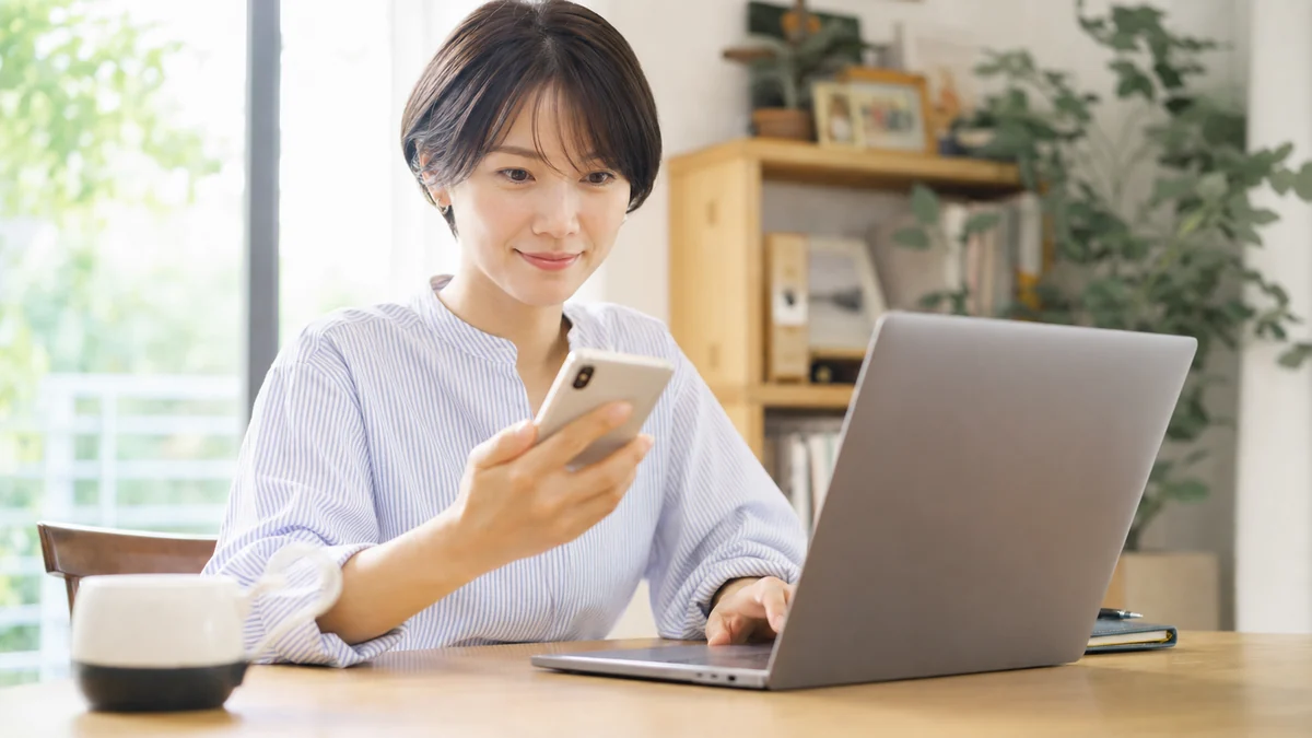 仮パスワードのメールを確認して再設定する女性