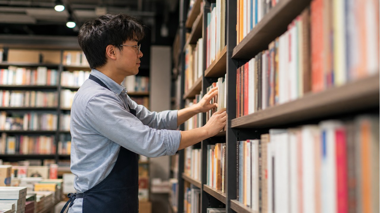 本屋 バイトで本棚の商品を整理するスタッフのイメージ