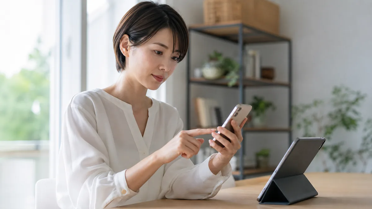 iPhoneとiPadのOS更新状況を確認する女性