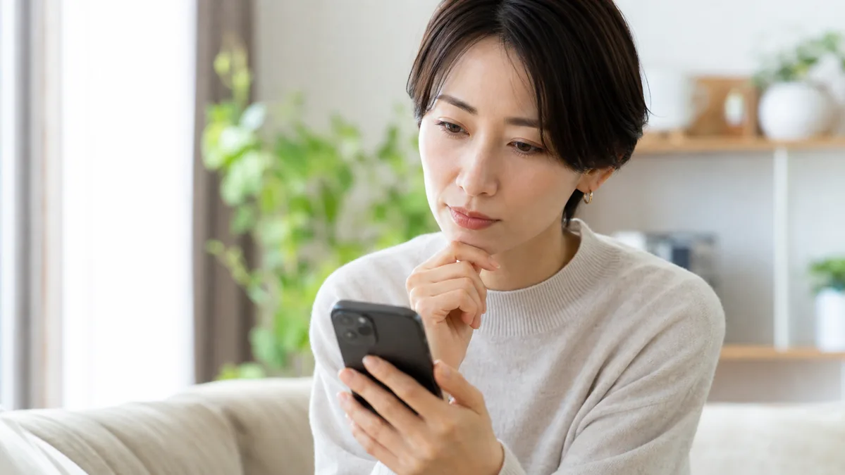 スマートフォンのプライバシー許可を確認する女性