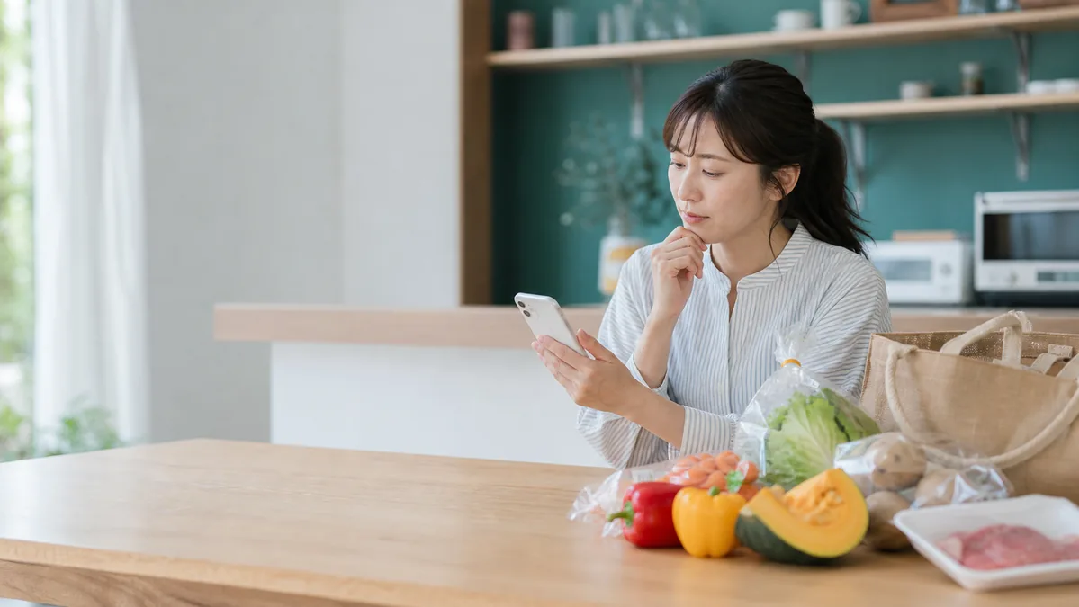 買い物後にスマートフォンで参加条件を確認する女性