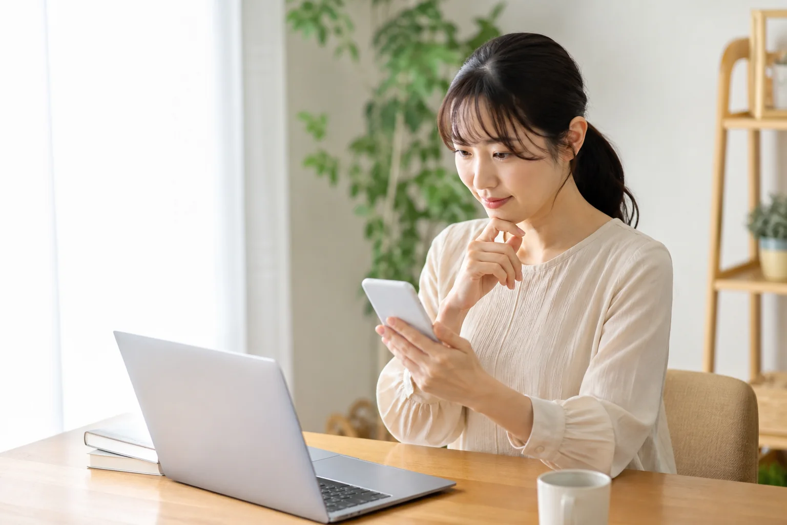 スマホとパソコンで同じアカウントを確認する女性